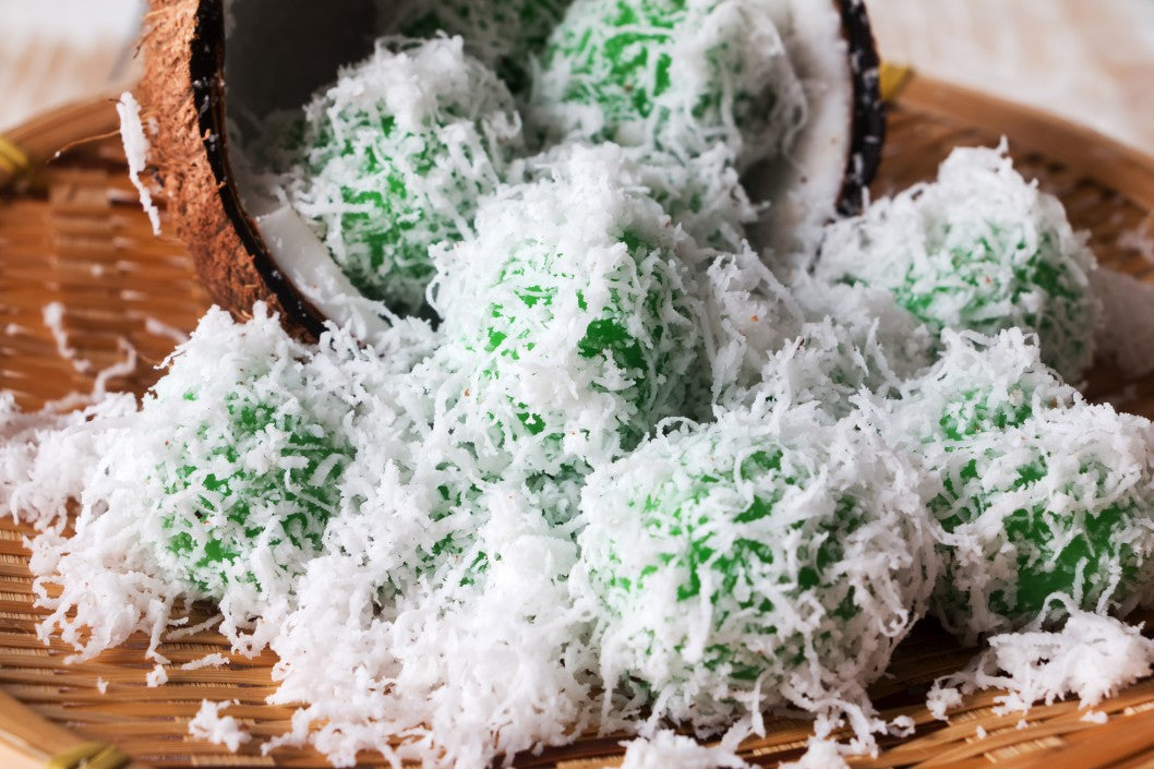 Onde-onde (also spelled as ondeh-ondeh) are made with pandan (screwpine leaf) infused dough and filled with Gula Melaka or palm sugar. Roll them with grated coconut before serving.